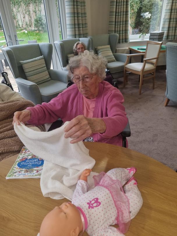 One of Cherry Blossom's residents demonstrating how to put a diaper on a baby
