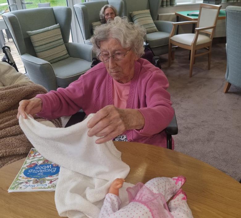 One of Cherry Blossom's residents demonstrating how to put a diaper on a baby