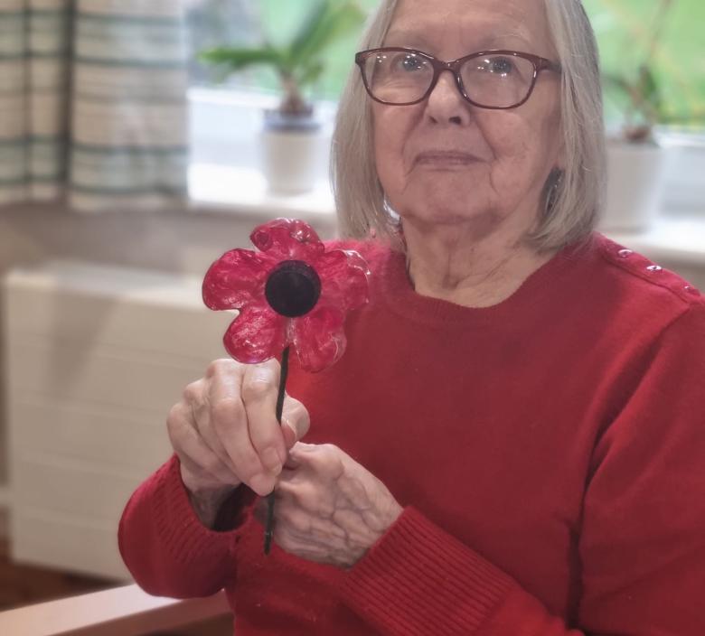 Cherry Blossom resident with the poppy she made for Remembrance Day