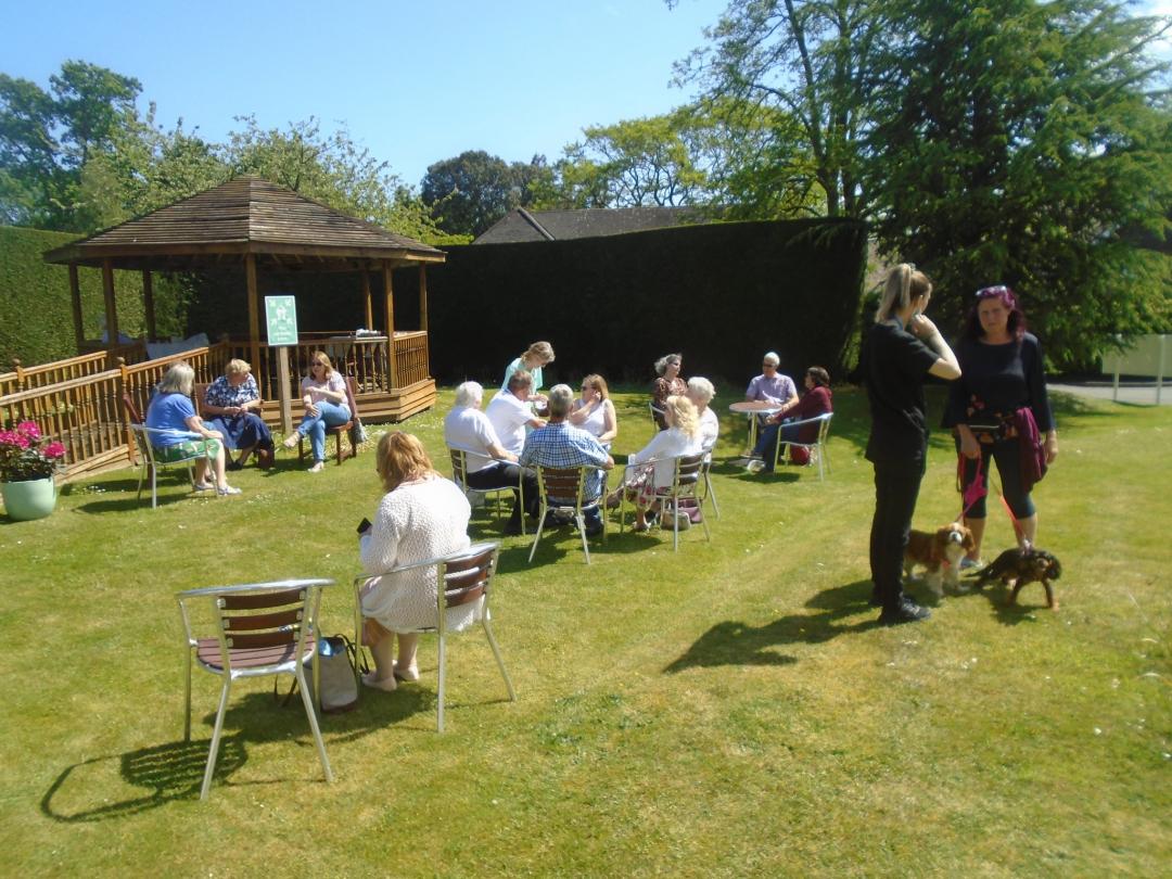 image of people sitting in a nursing home garden after remembrance service