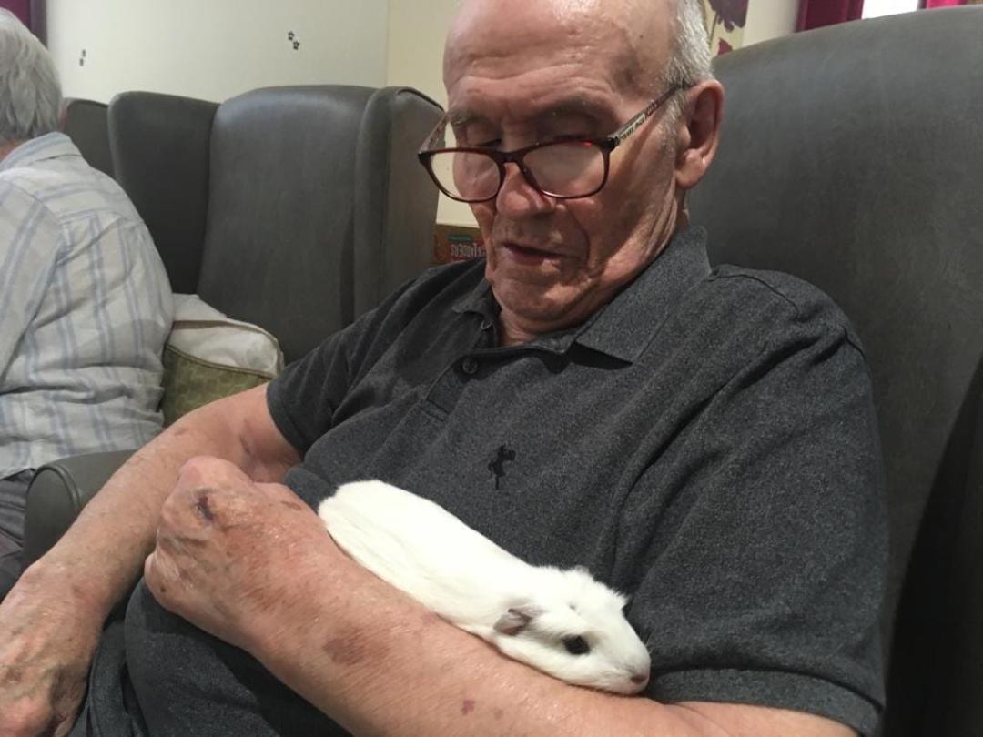 care home resident holding a guinea pig
