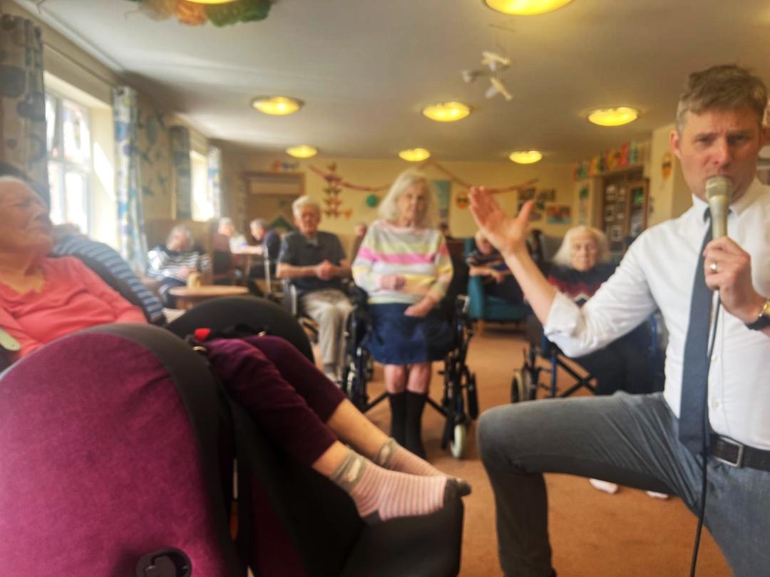 Mike Siddaway singing to a resident at Fordingbridge