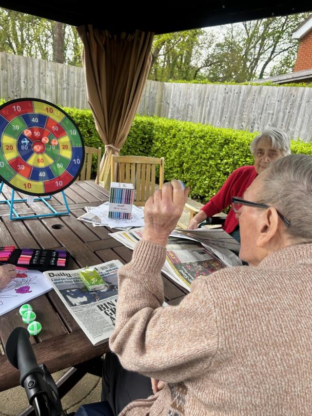Resident enjoying playing Velcro Darts in the sun
