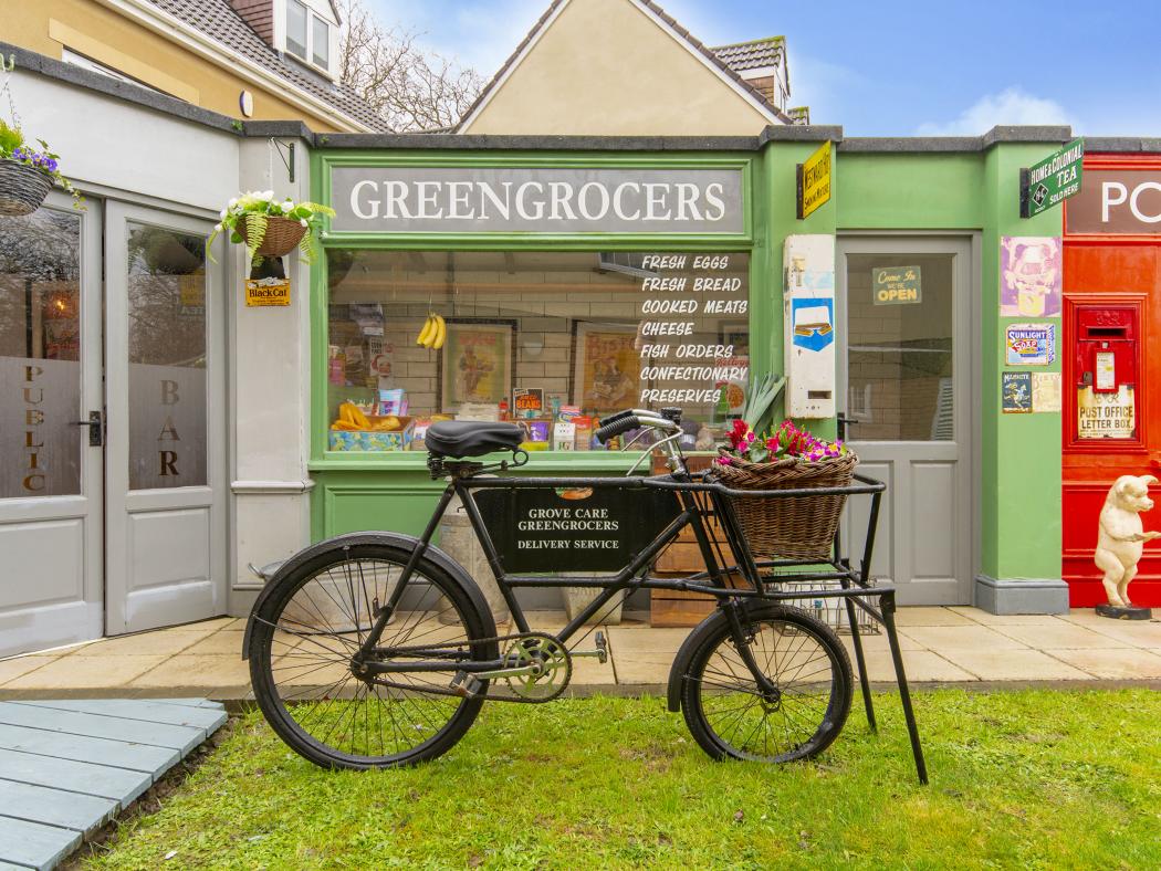 Charming greengrocers shopfront at Blossom Fields, featuring a traditional delivery bicycle