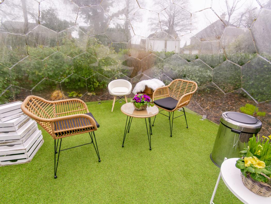 Cozy seating area inside a garden pod at Blossom Fields, offering a peaceful outdoor retreat