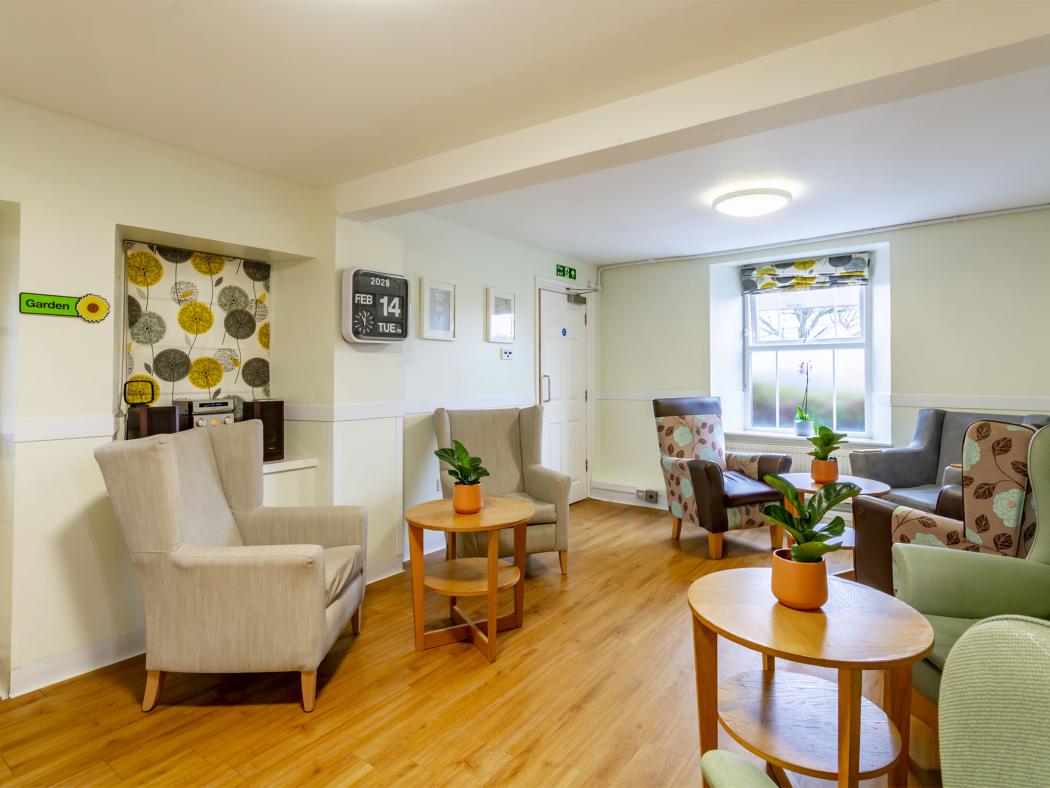 A cosy seating area with various armchairs arranged around wooden tables