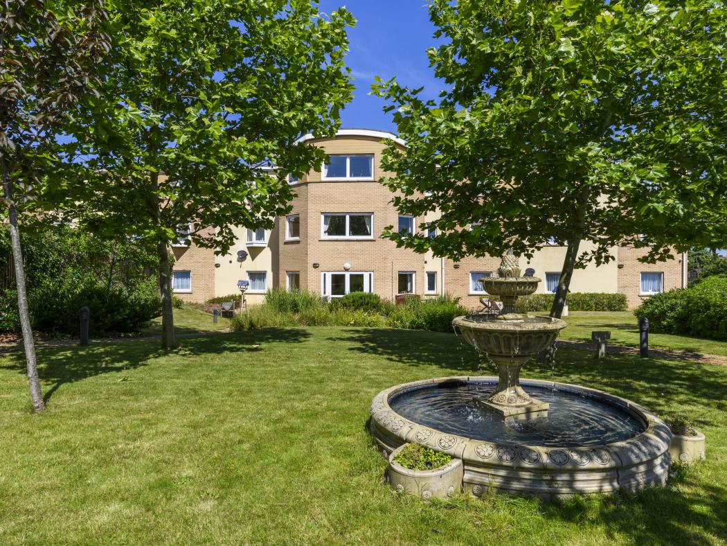 Cherry Blossom Care Home garden on a sunny day with fountain flowing