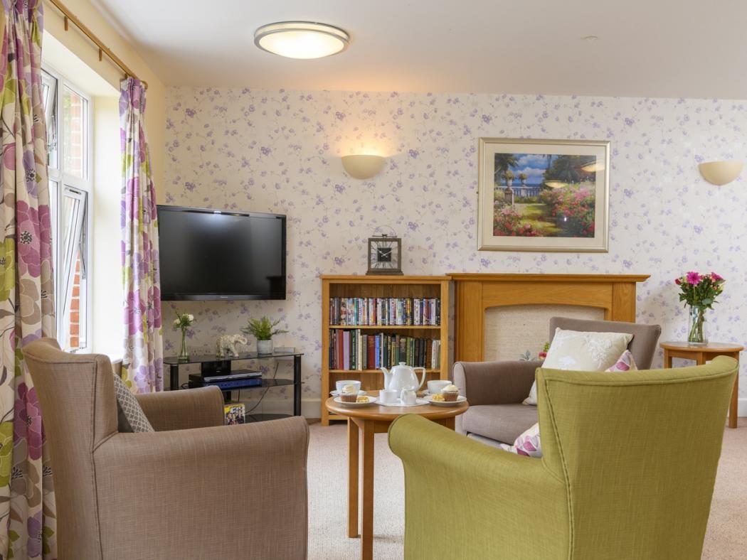 living room with tv and arm chairs facing the screen in a care home