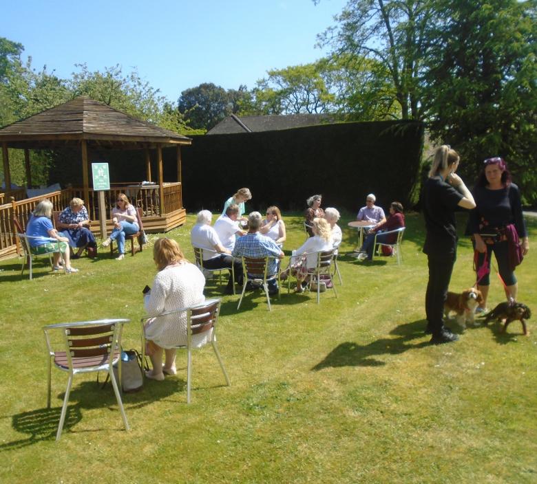 image of people sitting in a nursing home garden after remembrance service