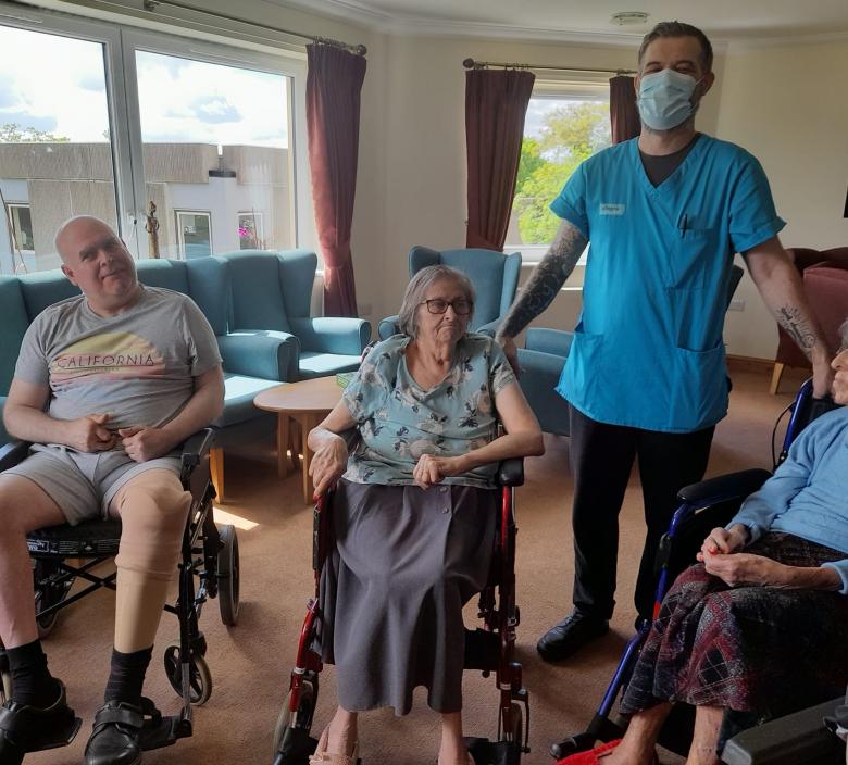 care home residents sat down ready for morning stretches with care staff in the middle