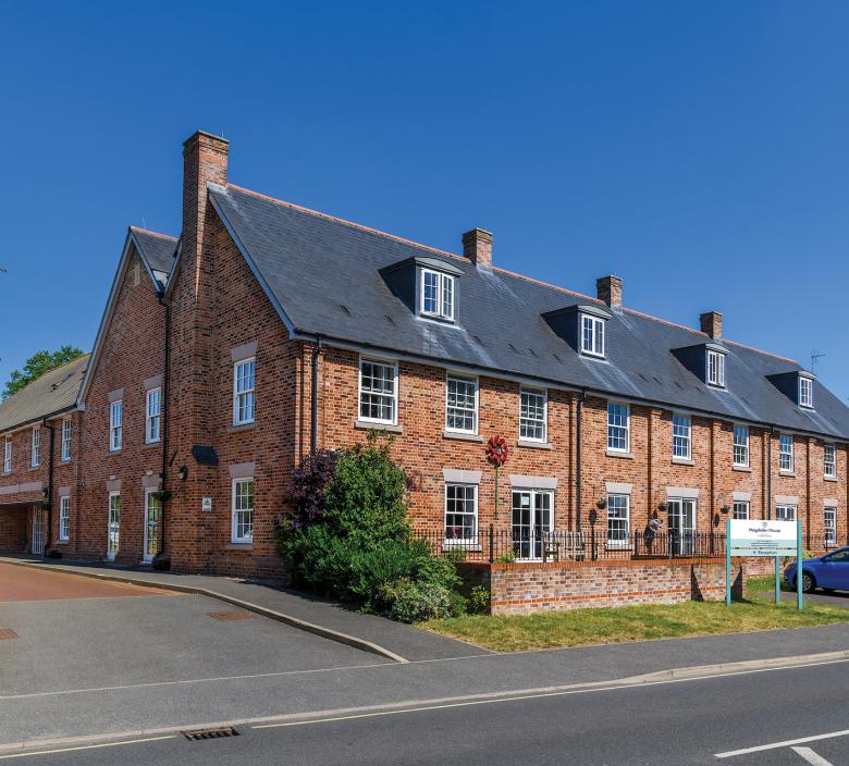 exterior of Magdalen House Care Home against blue skies