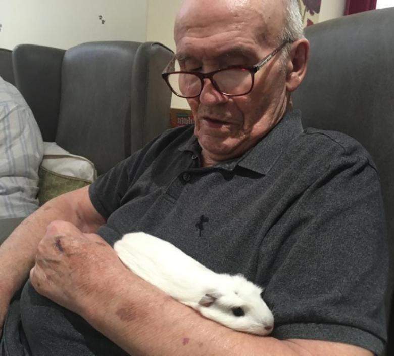 care home resident holding a guinea pig