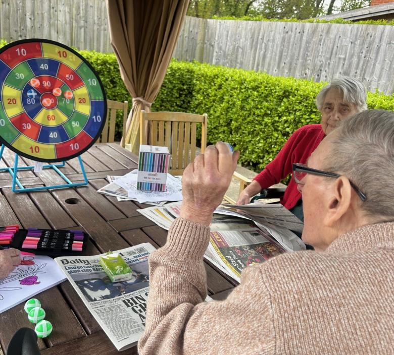 Resident enjoying playing Velcro Darts in the sun
